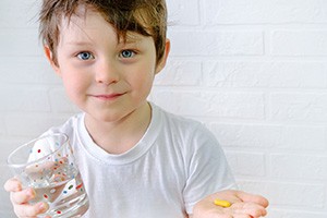 Young boy preparing to swallow a pill