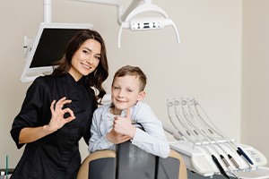 Happy boy posing with dental team member