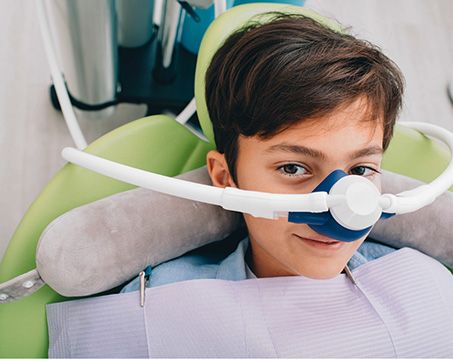 Smiling boy in dental chair receiving sedation dentistry