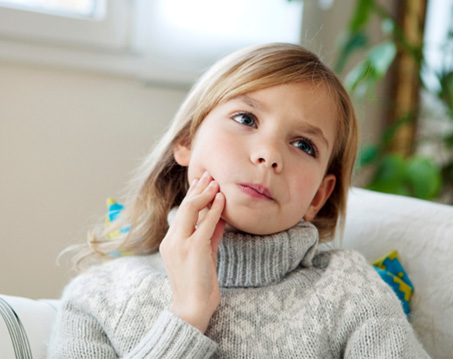 Grimacing young girl with a toothache