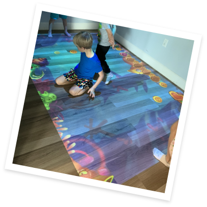 Kids playing on floor lit up like the ocean