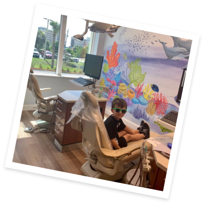 Young boy with sunglasses sitting in dental chair