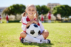 Child smiles with soccer ball