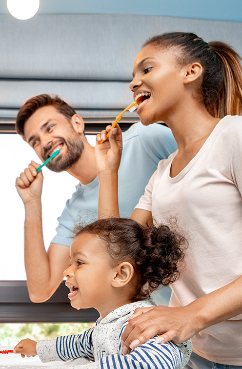 Mother father and child brushing their teeth together