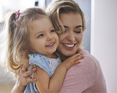 Mother and young daughter hugging